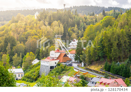 A historic mining tower rises against the backdrop of lush forests in Jachymov, Czechia. The structure reflects the region's rich mining heritage and scenic beauty. A historic mining tower rises against the backdrop of lush forests in Jachymov, Czechia. The structure reflects the region's rich mining heritage and scenic beauty. 128170434