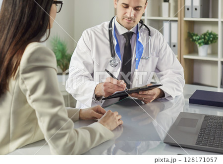 Doctor Issuing Prescription For Patient In Hospital 128171057