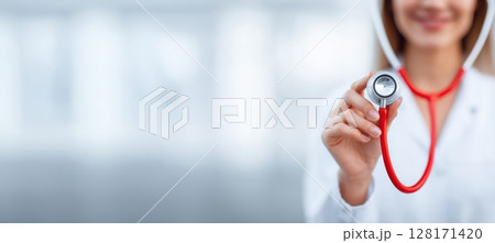A smiling healthcare professional with a stethoscope provides compassionate patient care 128171420