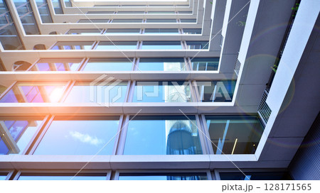 Downtown corporate business district architecture. Glass reflective office buildings against blue sky and sun light. Economy, finances, business activity concept. Abstract modern architecture fragment Downtown corporate business district architecture. Glass reflective office buildings against blue sky and sun light. Economy, finances, business activity concept. Abstract modern architecture fragment 128171565