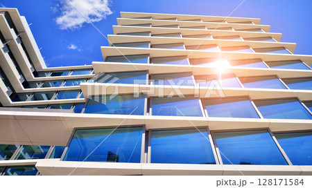 Downtown corporate business district architecture. Glass reflective office buildings against blue sky and sun light. Economy, finances, business activity concept. Abstract modern architecture fragment Downtown corporate business district architecture. Glass reflective office buildings against blue sky and sun light. Economy, finances, business activity concept. Abstract modern architecture fragment 128171584