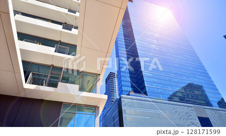 Downtown corporate business district architecture. Glass reflective office buildings against blue sky and sun light. Economy, finances, business activity concept. Abstract modern architecture fragment 128171599