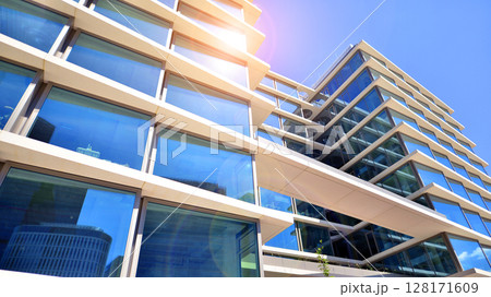 Downtown corporate business district architecture. Glass reflective office buildings against blue sky and sun light. Economy, finances, business activity concept. Abstract modern architecture fragment 128171609