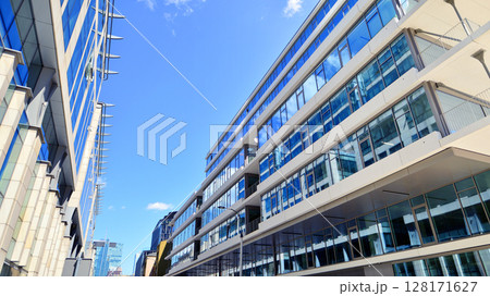 Downtown corporate business district architecture. Glass reflective office buildings against blue sky and sun light. Economy, finances, business activity concept. Abstract modern architecture fragment 128171627