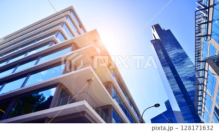 Downtown corporate business district architecture. Glass reflective office buildings against blue sky and sun light. Economy, finances, business activity concept. Abstract modern architecture fragment 128171632