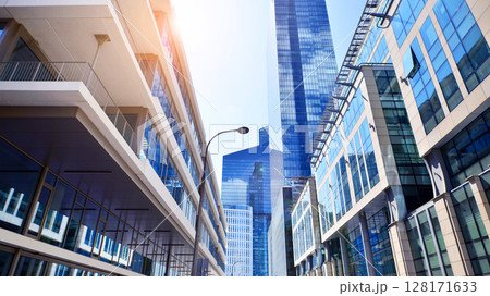 Downtown corporate business district architecture. Glass reflective office buildings against blue sky and sun light. Economy, finances, business activity concept. Abstract modern architecture fragment Downtown corporate business district architecture. Glass reflective office buildings against blue sky and sun light. Economy, finances, business activity concept. Abstract modern architecture fragment 128171633