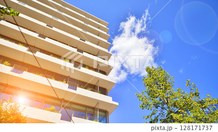 City life, urban landscape and ecology. Modern office complex with glass facades and smooth lines against backdrop of green trees, concept of modern architecture. Organically building into nature. City life, urban landscape and ecology. Modern office complex with glass facades and smooth lines against backdrop of green trees, concept of modern architecture. Organically building into nature. 128171737