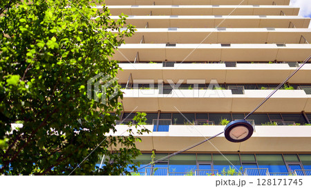 City life, urban landscape and ecology.  Modern office complex with glass facades and smooth lines against backdrop of green trees, concept of modern architecture. Organically building into nature.   128171745