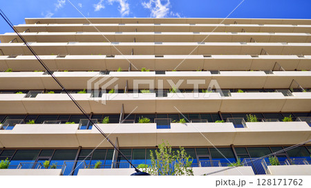City life, urban landscape and ecology. Modern office complex with glass facades and smooth lines against backdrop of green trees, concept of modern architecture. Organically building into nature. City life, urban landscape and ecology. Modern office complex with glass facades and smooth lines against backdrop of green trees, concept of modern architecture. Organically building into nature. 128171762