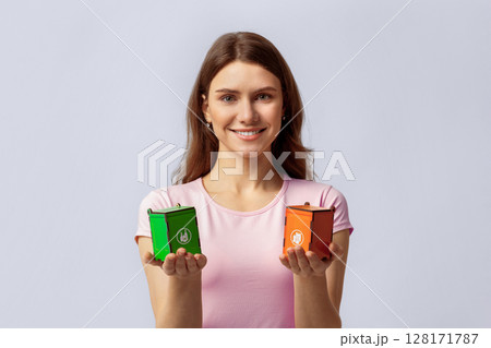Waste Separation Concept. Portrait Of Happy Young Beautiful Woman Holding Little Wooden Toy Recycle Bins For Different Type Of Materials, Eco-Activist Lady Standing On Light Studio Background 128171787