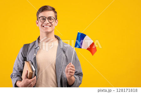 European education, modern study or exchange student. Young happy guy in glasses with backpack, notepads and small flag of France, isolated on orange background, copy space, studio shot European education, modern study or exchange student. Young happy guy in glasses with backpack, notepads and small flag of France, isolated on orange background, copy space, studio shot 128171818