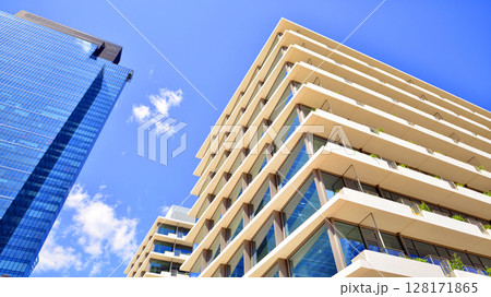 Downtown corporate business district architecture. Glass reflective office buildings against blue sky and sun light. Economy, finances, business activity concept. Abstract modern architecture fragment Downtown corporate business district architecture. Glass reflective office buildings against blue sky and sun light. Economy, finances, business activity concept. Abstract modern architecture fragment 128171865