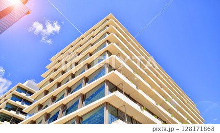 Downtown corporate business district architecture. Glass reflective office buildings against blue sky and sun light. Economy, finances, business activity concept. Abstract modern architecture fragment Downtown corporate business district architecture. Glass reflective office buildings against blue sky and sun light. Economy, finances, business activity concept. Abstract modern architecture fragment 128171868