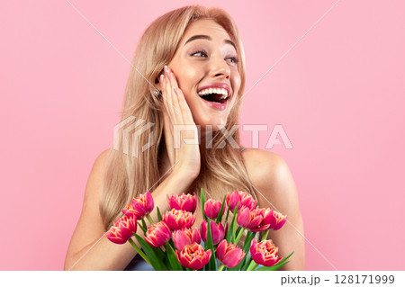 Portrait of beautiful young lady with lovely flowers feeling excited on pink studio background. Pretty blonde with bouquet of tulips as Woman's Day gift. Spring holiday concept Portrait of beautiful young lady with lovely flowers feeling excited on pink studio background. Pretty blonde with bouquet of tulips as Woman's Day gift. Spring holiday concept 128171999