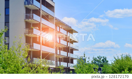 European residential architecture harmonizing with nature. Eco-friendly living in city with greens. Eco apartment building saving energy and fresh air concept.  128172170