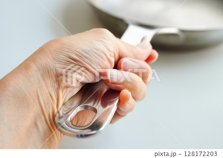 フライパンを握る女性の手元 クローズアップ フライパンを握る女性の手元 クローズアップ 128172203