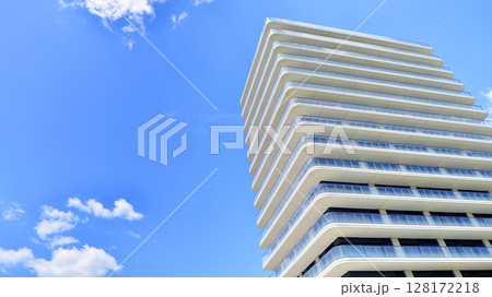 Exterior of a high modern multi-story apartment building - facade, windows and balconies. Modern glass balcony railings. 128172218