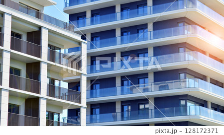 Modern apartment buildings on a sunny day with a blue sky. Facade of a modern apartment building. Modern residential apartment building complex condo. Modern apartment buildings on a sunny day with a blue sky. Facade of a modern apartment building. Modern residential apartment building complex condo. 128172371