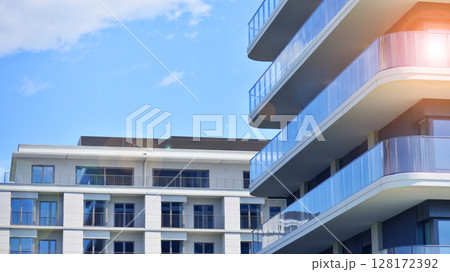 Modern apartment buildings on a sunny day with a blue sky. Facade of a modern apartment building. Modern residential apartment building complex condo. Modern apartment buildings on a sunny day with a blue sky. Facade of a modern apartment building. Modern residential apartment building complex condo. 128172392