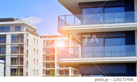 Modern apartment buildings on a sunny day with a blue sky. Facade of a modern apartment building. Modern residential apartment building complex condo. Modern apartment buildings on a sunny day with a blue sky. Facade of a modern apartment building. Modern residential apartment building complex condo. 128172406