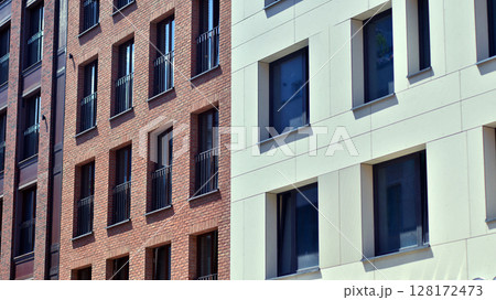 Modern apartment buildings on a sunny day with a blue sky. Facade of a modern apartment building. Modern residential apartment building complex condo. 128172473