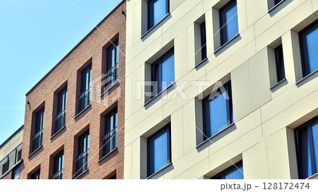Modern apartment buildings on a sunny day with a blue sky. Facade of a modern apartment building. Modern residential apartment building complex condo. Modern apartment buildings on a sunny day with a blue sky. Facade of a modern apartment building. Modern residential apartment building complex condo. 128172474
