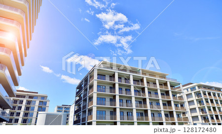 Modern apartment buildings on a sunny day with a blue sky. Facade of a modern apartment building. Modern residential apartment building complex condo. Modern apartment buildings on a sunny day with a blue sky. Facade of a modern apartment building. Modern residential apartment building complex condo. 128172480