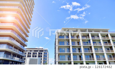 Modern apartment buildings on a sunny day with a blue sky. Facade of a modern apartment building. Modern residential apartment building complex condo. Modern apartment buildings on a sunny day with a blue sky. Facade of a modern apartment building. Modern residential apartment building complex condo. 128172482