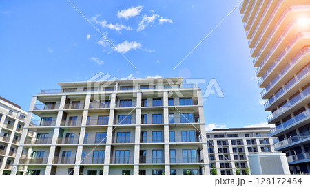 Modern apartment buildings on a sunny day with a blue sky. Facade of a modern apartment building. Modern residential apartment building complex condo. 128172484
