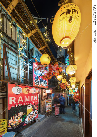 [東京・新宿] 思い出横丁の狭い路地でラーメンショップの看板を照らす提灯。 128172798