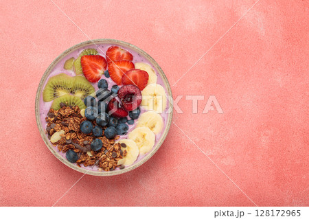 Delicious acai bowl with fresh fruits and granola in white ceramic bowl on pink table top view, healthy breakfast or snack, copy space Delicious acai bowl with fresh fruits and granola in white ceramic bowl on pink table top view, healthy breakfast or snack, copy space 128172965