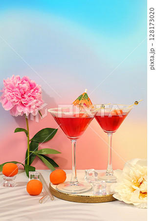 Minimal summer party concept, advertising banner for bar, cafe. Modern still life with pink martini, summer alcoholic cocktail with apricot for party and peonies on elegant modern background 128173020