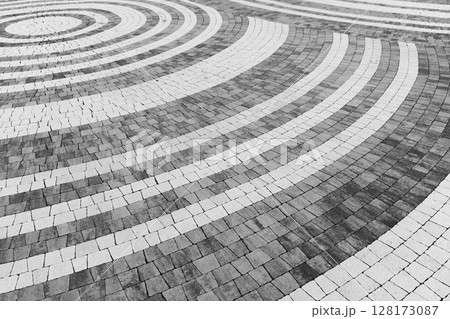 Artistic pattern of concentric white circular lines, decorative stone pavement Artistic pattern of concentric white circular lines, decorative stone pavement 128173087