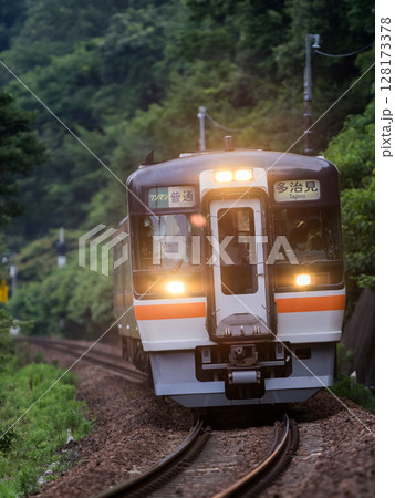 【高山本線】夕暮れの山間部を走行する普通列車 128173378