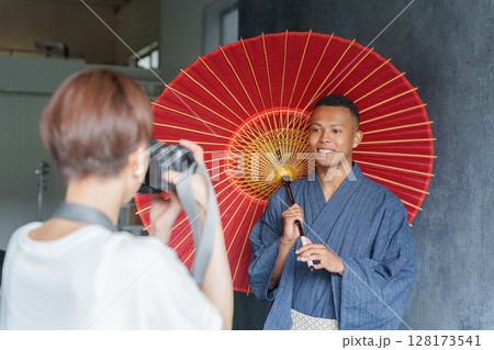 浴衣を着た外国人観光客と撮影するカメラマン 浴衣を着た外国人観光客と撮影するカメラマン 128173541