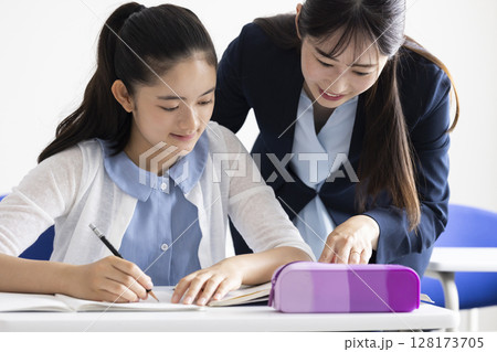 勉強する子どもと教える先生 勉強する子どもと教える先生 128173705