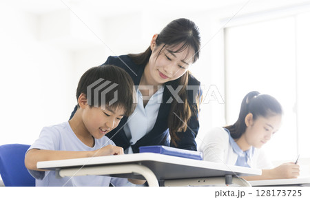 勉強をする小学生と先生 勉強をする小学生と先生 128173725