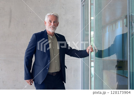 Senior businessman in suit entering modern office Senior businessman in suit entering modern office 128173904