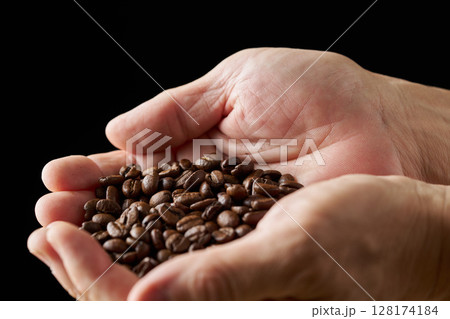 手に持ったコーヒー豆 128174184