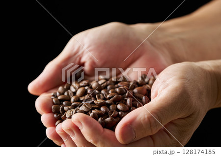 手に持ったコーヒー豆 手に持ったコーヒー豆 128174185