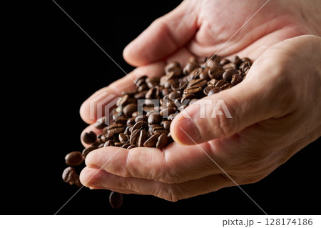 手に持ったコーヒー豆 手に持ったコーヒー豆 128174186