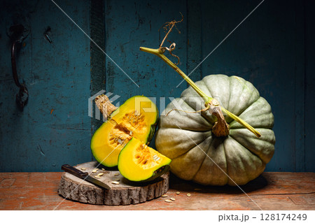 Pumpkins on an old wooden table with knife and seeds 128174249