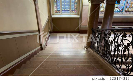 An Elegant Staircase Surrounded by Stunning Stained Glass Windows and Warm Ambiance 128174315
