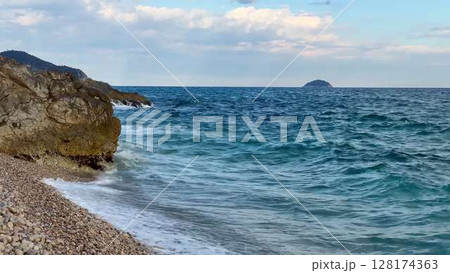 A tranquil coastal scene with a beautiful rocky shoreline and clear waters extending to the horizon A tranquil coastal scene with a beautiful rocky shoreline and clear waters extending to the horizon 128174363