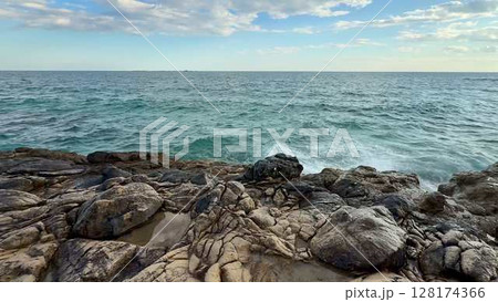 A Serene Coastal View Featuring Waves Gently Crashing Against the Rocky Shoreline 128174366
