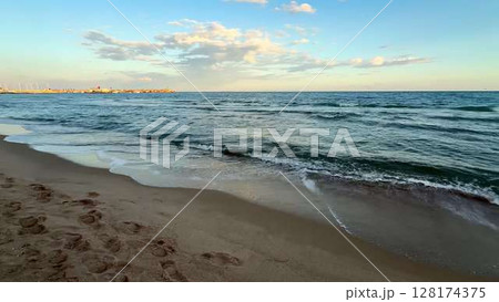 Experience Beautiful Beach Waves at Sunset Over a Calm Ocean, Perfect for Relaxation 128174375