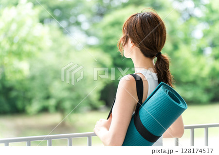 ストレス解消・リフレッシュに公園でヨガをする女性・ヨガマット 128174517