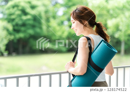 ストレス解消・リフレッシュに公園でヨガをする女性・ヨガマット 128174522