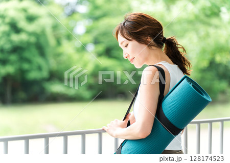 ストレス解消・リフレッシュに公園でヨガをする女性・ヨガマット 128174523