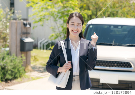 車の横に立つガッツポーズの女性 128175894